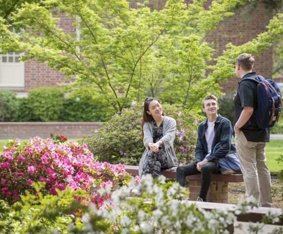 students sitting next to flowers