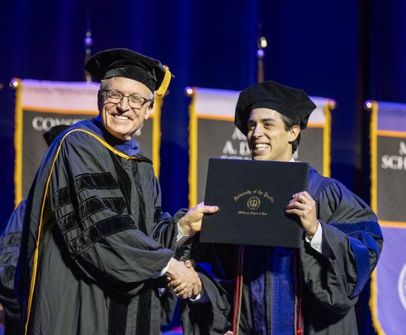A graduate is awarded their diploma