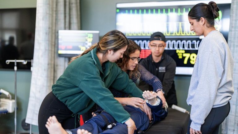 Students working with mannekin in clinical lab