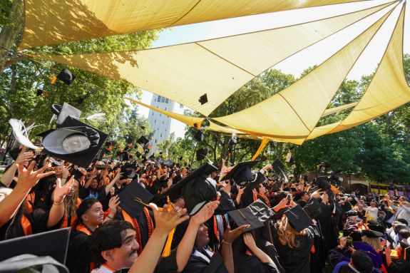 students throwing their caps