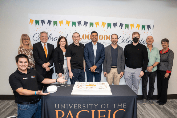 picture from the $1 million saved event of faculty, staff, students, president, provost, with a celebratory cake