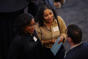 Aerial view of students speaking with an employer.
