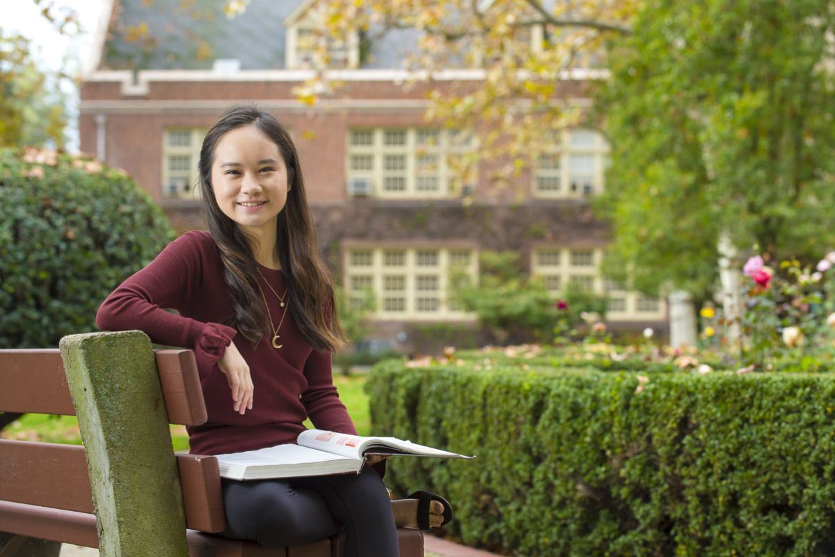 Language student sitting on campus bench