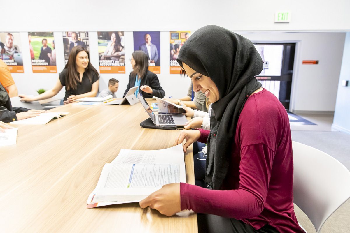 student in classroom looking at textbook