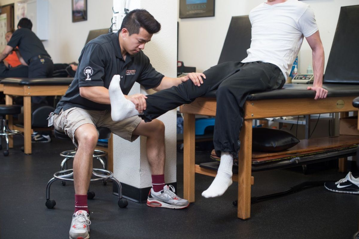 student administering therapy to athlete
