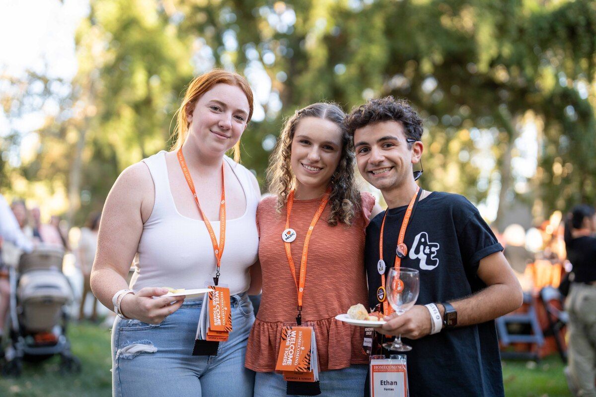 group of three young alumni standing together