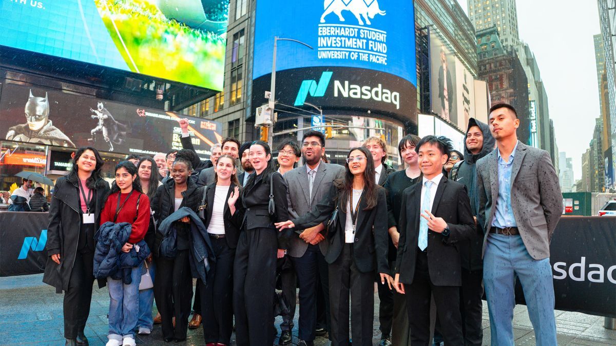 Studnets post in front of NASDAQ
