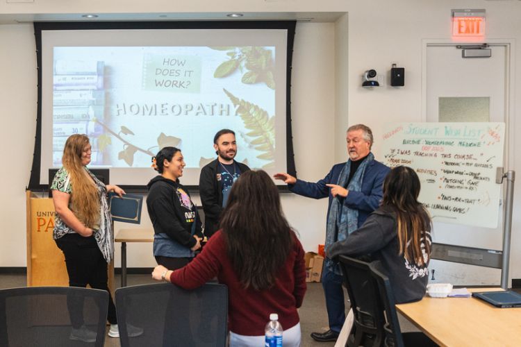 A group of students stands in front of a projection screen