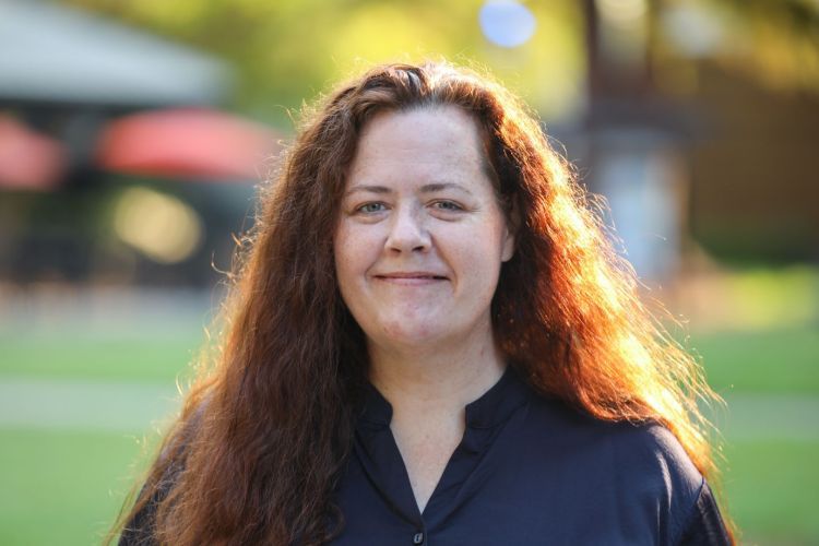 Woman in business attire in an outdoor setting. 