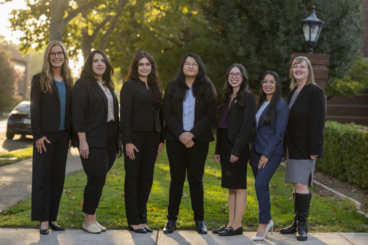 A group of seven women pose for a photo outdoors