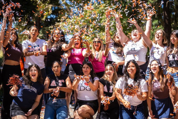 Group of students cheering and throwing confetti