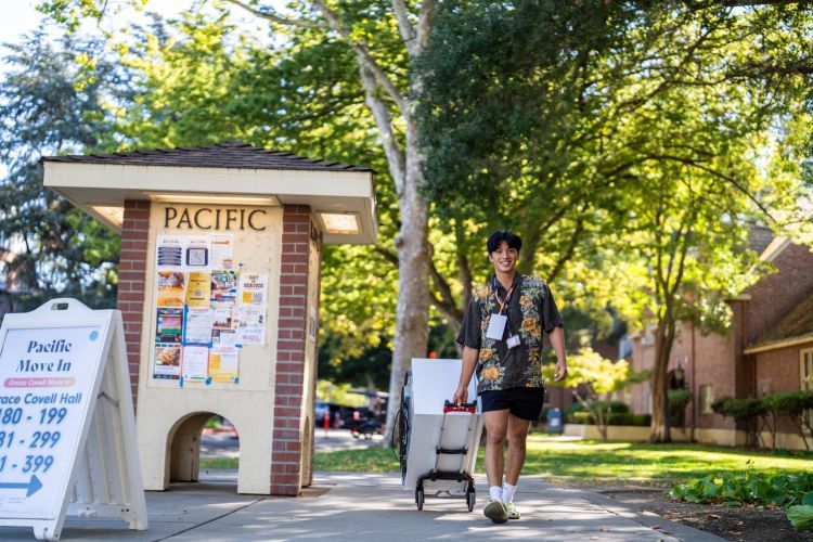 A Pacific student moving items in a tote