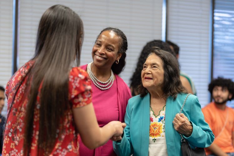 Dolores Huerta with Vice President for DEI, Mary Lomax-Ghirarduzzi, greeting a student.