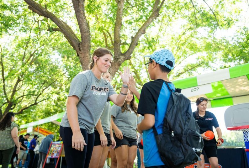 softball player high fives child