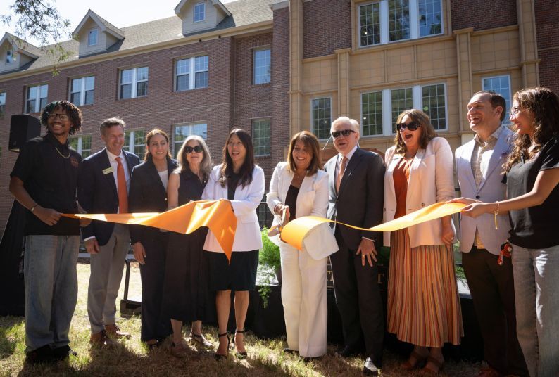 University and state leader cut an orange ribbon outside of Southwest Hall