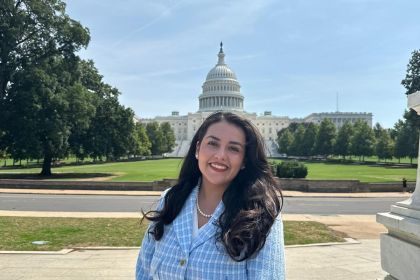 A woman poses for a photo in front of the U.S. Capitol Building 
