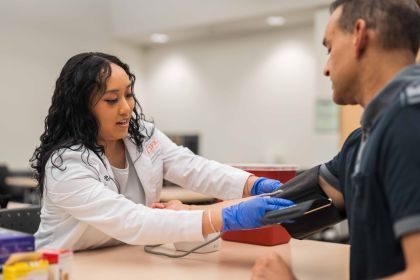 A student practices checking blood pressure