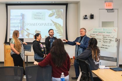 A group of students stands in front of a projection screen