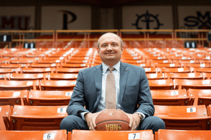 Adam Tschour sits in the stands among orange seats.