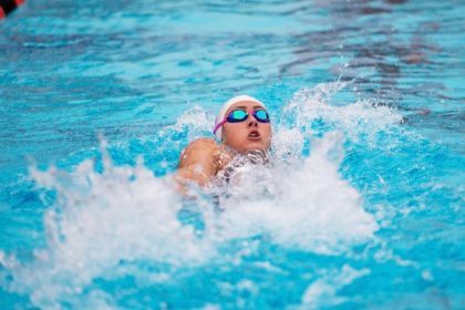 Macy Coad swims in the water.
