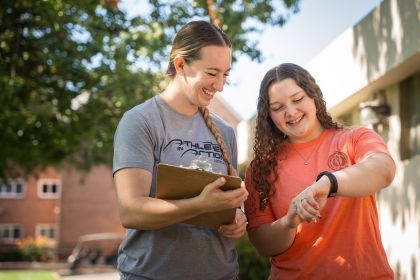 Two students looking at fitness tracker.