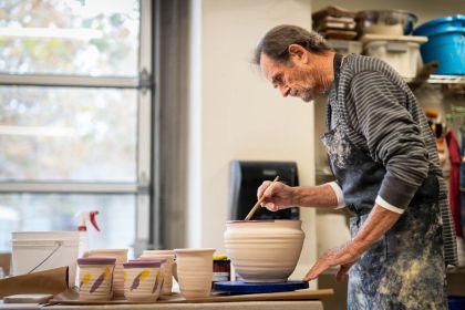 A man paints pottery.