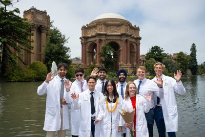 a group of students in their white coats in front of the Palace of Fine Arts.