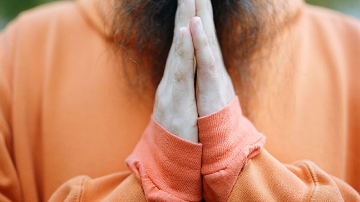 Orange sweatshirt prayer hands