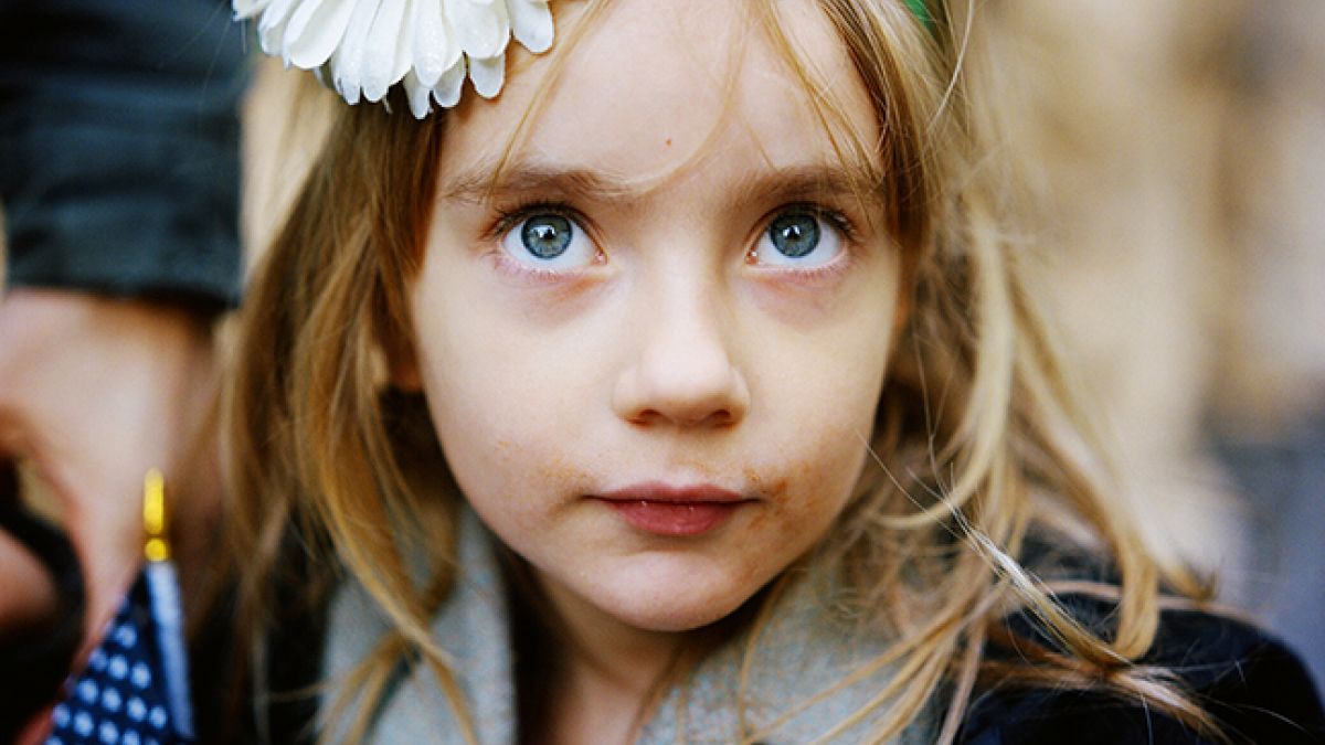 Blue eyed girl with daisy on her headband